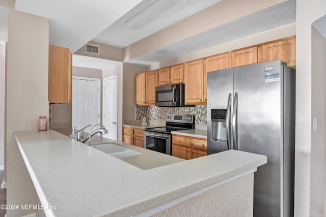 kitchen with sink, light brown cabinetry, tasteful backsplash, kitchen peninsula, and stainless steel appliances