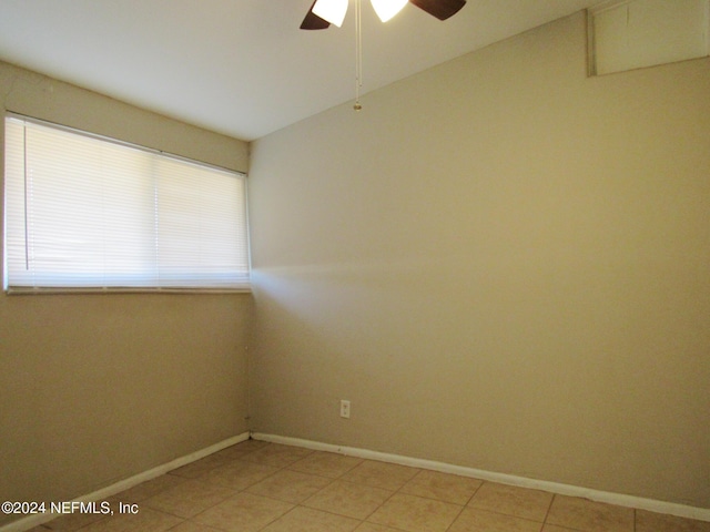 empty room with ceiling fan and light tile patterned flooring