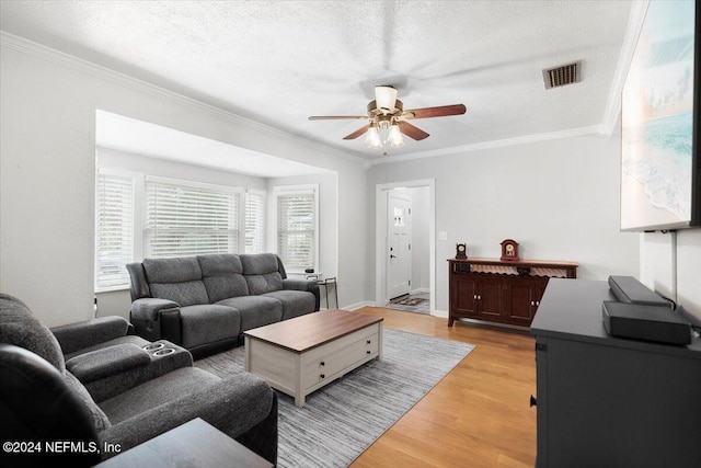 living room featuring a textured ceiling, light hardwood / wood-style floors, ceiling fan, and ornamental molding