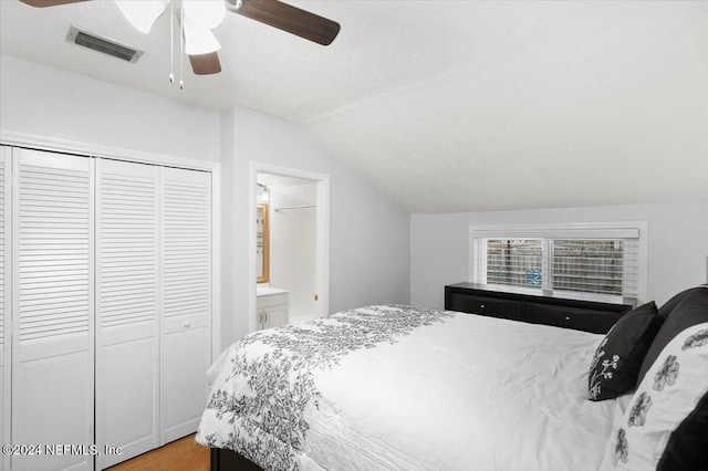 bedroom with ceiling fan, lofted ceiling, a textured ceiling, and a closet