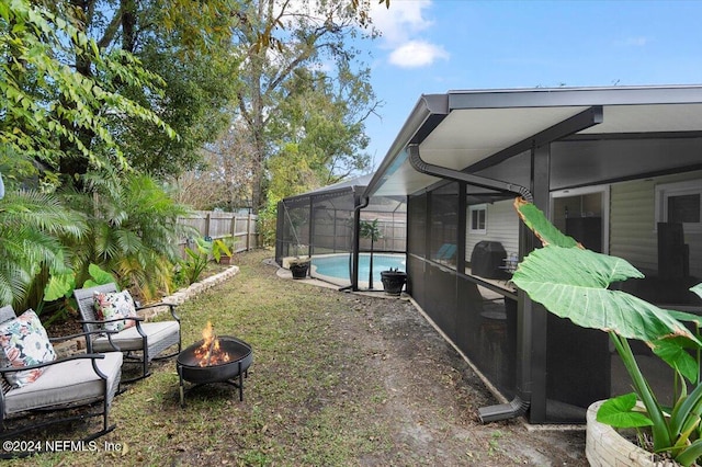 view of yard with a fire pit, glass enclosure, and a fenced in pool