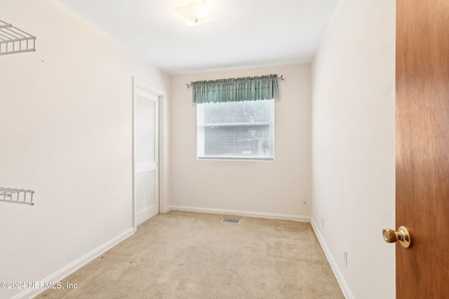 unfurnished room with light colored carpet