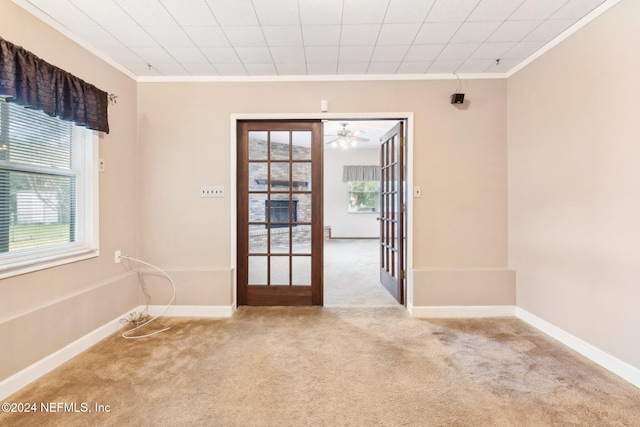 spare room with french doors, light colored carpet, ceiling fan, and ornamental molding