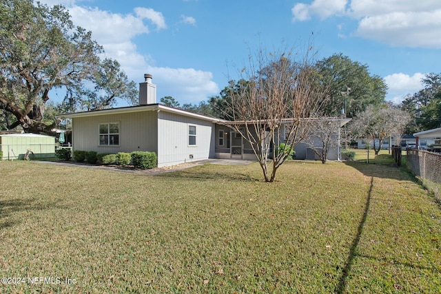 rear view of property featuring a lawn