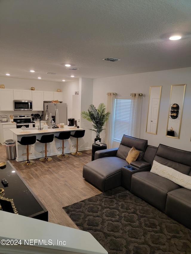 living room with light hardwood / wood-style floors and a textured ceiling