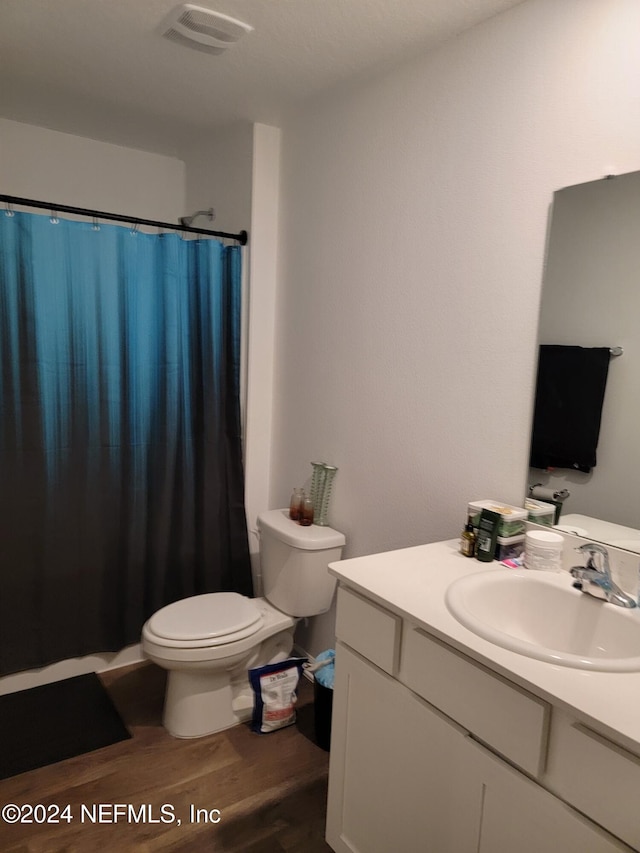 bathroom featuring a shower with shower curtain, vanity, hardwood / wood-style flooring, and toilet