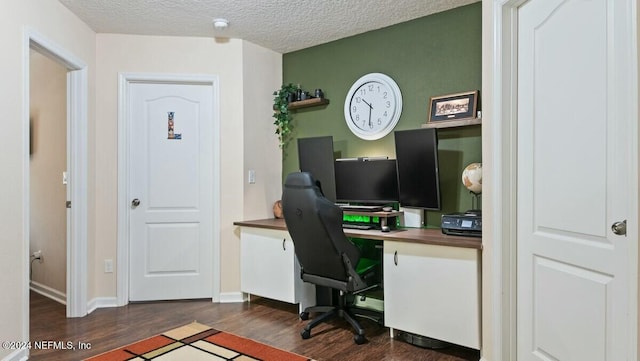 office area with dark hardwood / wood-style floors and a textured ceiling