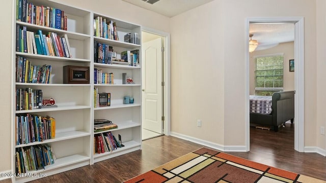 sitting room featuring ceiling fan and dark wood-type flooring