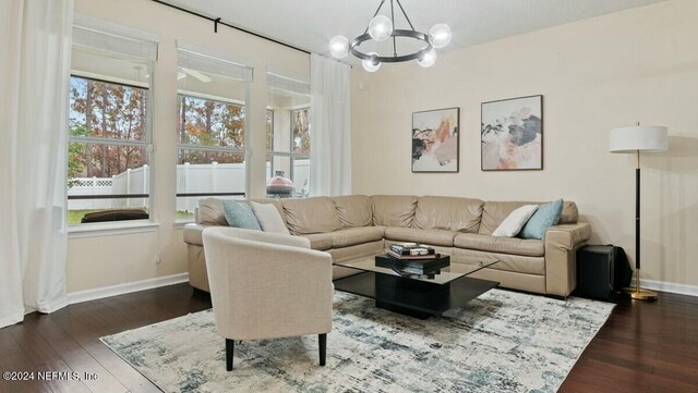 living room featuring a chandelier and dark wood-type flooring