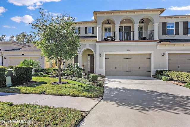 view of front of home with a balcony, a front yard, and a garage