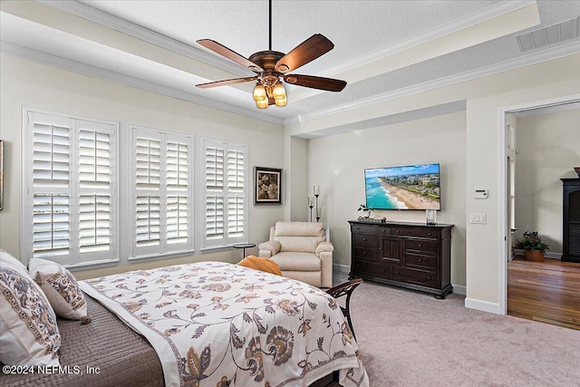 bedroom with ceiling fan, light colored carpet, ornamental molding, and a textured ceiling