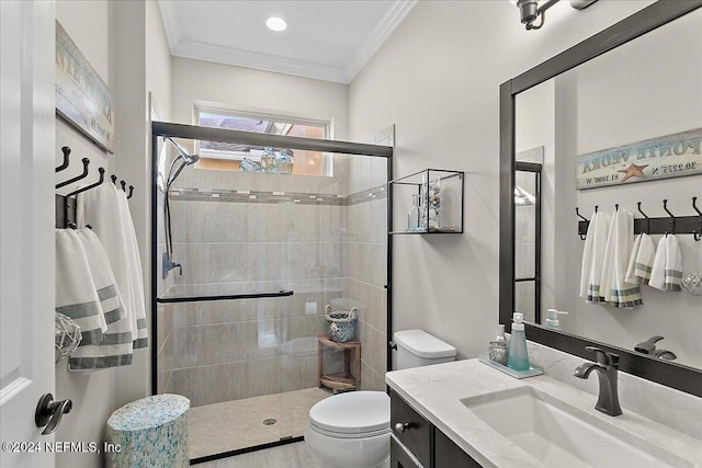 bathroom featuring toilet, vanity, a shower with door, and ornamental molding