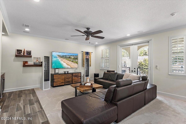 living room with crown molding, ceiling fan, and a textured ceiling