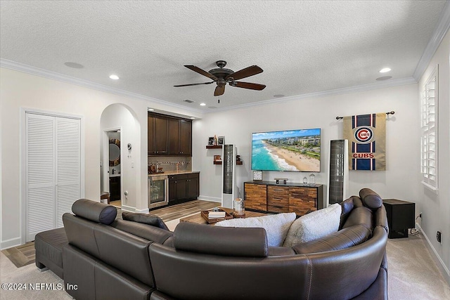 living room with crown molding, beverage cooler, and a textured ceiling