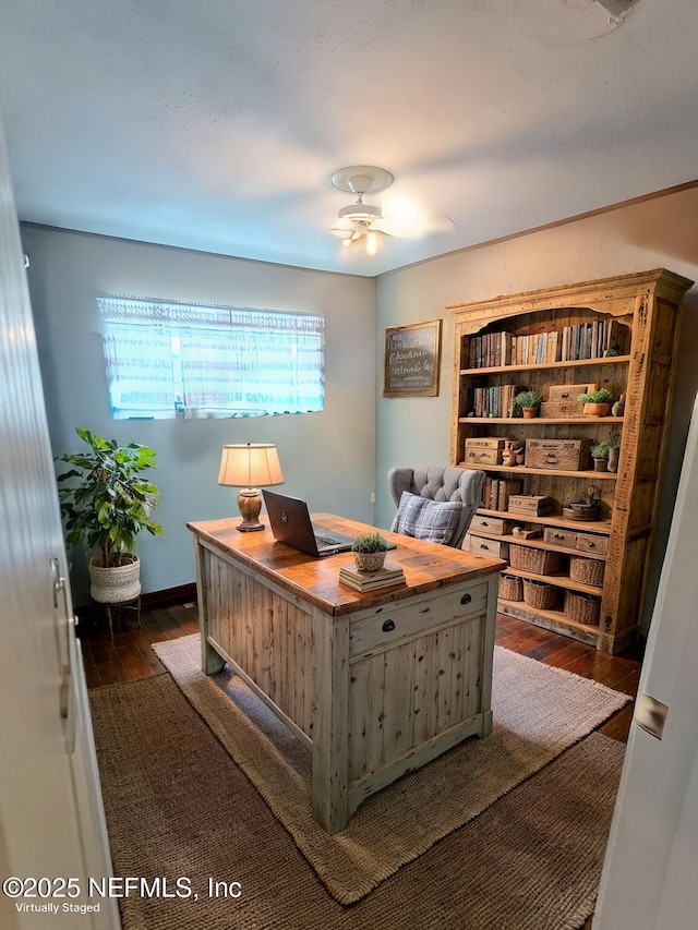 office with dark wood finished floors and ceiling fan