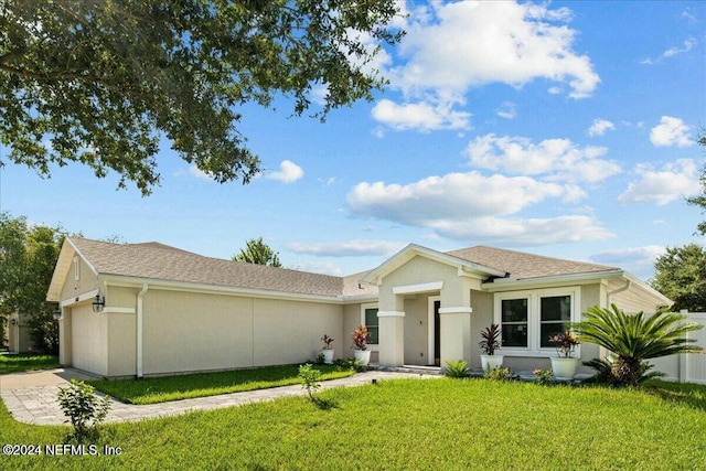 ranch-style house with a garage and a front lawn