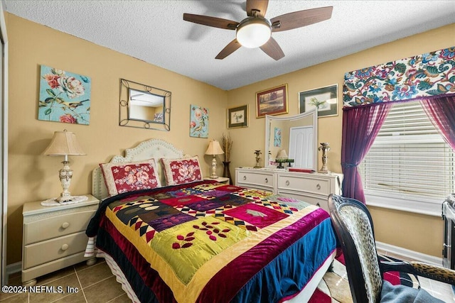 tiled bedroom featuring a textured ceiling and ceiling fan