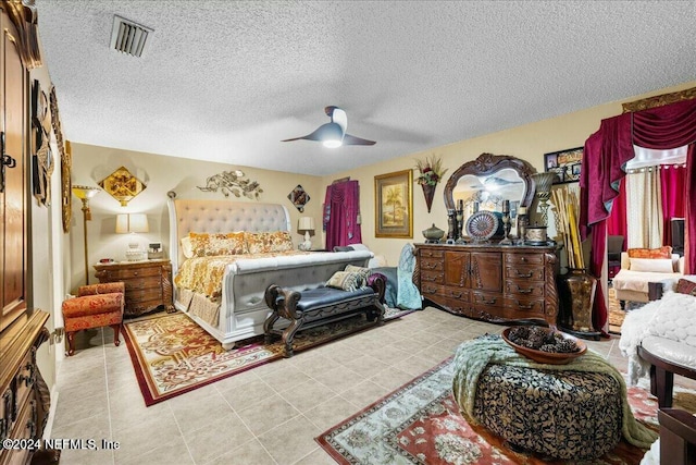 bedroom featuring light tile patterned floors, a textured ceiling, and ceiling fan