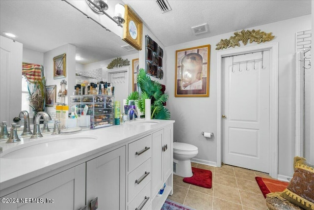 bathroom featuring tile patterned floors, an enclosed shower, a textured ceiling, toilet, and vanity