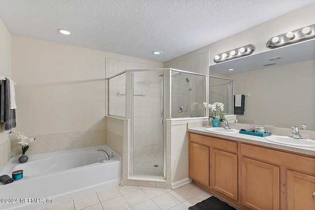 bathroom featuring tile patterned floors, separate shower and tub, vanity, and a textured ceiling