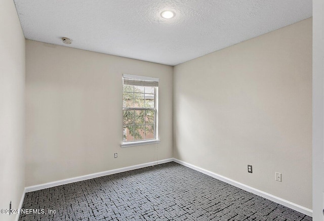 spare room with a textured ceiling