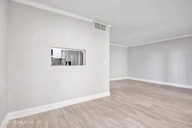 unfurnished room with light hardwood / wood-style floors and crown molding