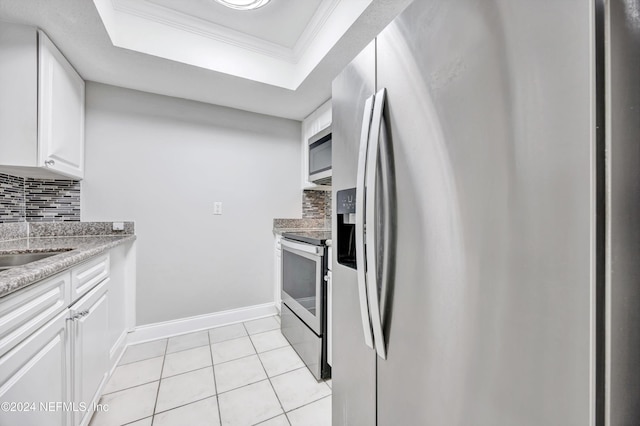 kitchen with decorative backsplash, ornamental molding, stainless steel appliances, a raised ceiling, and white cabinets