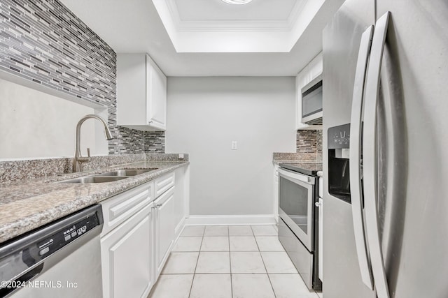 kitchen with white cabinets, a raised ceiling, sink, decorative backsplash, and appliances with stainless steel finishes