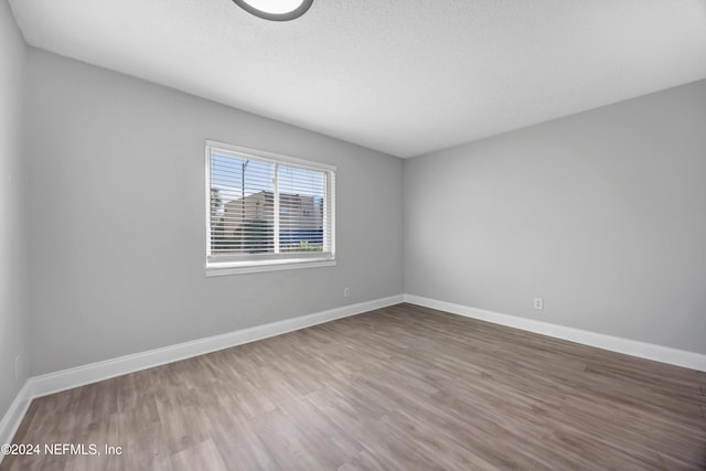 empty room with a textured ceiling and hardwood / wood-style flooring