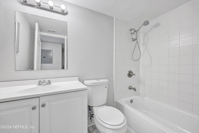 full bathroom featuring vanity, tiled shower / bath combo, and toilet