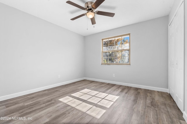 unfurnished bedroom featuring ceiling fan, wood-type flooring, and a closet