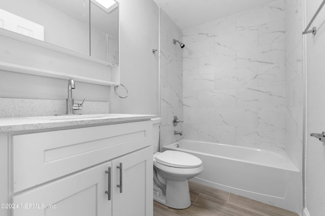 full bathroom with toilet, vanity, and tiled shower / bath