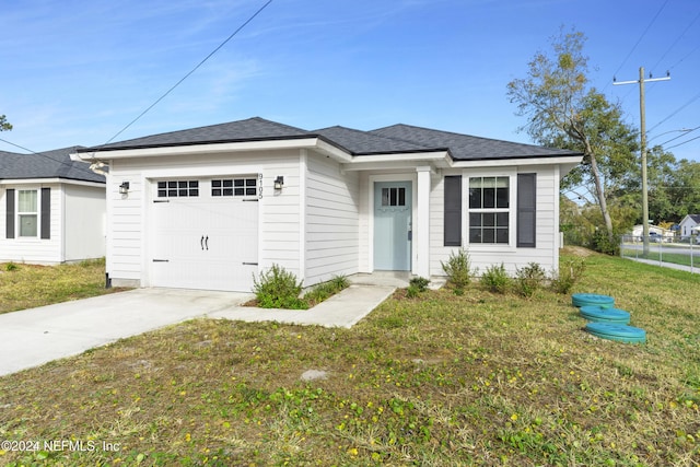 view of front of home with a front yard and a garage