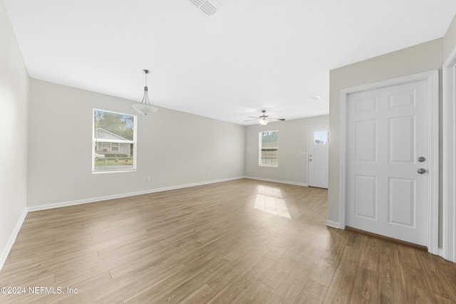 unfurnished room featuring light wood-type flooring, plenty of natural light, and ceiling fan