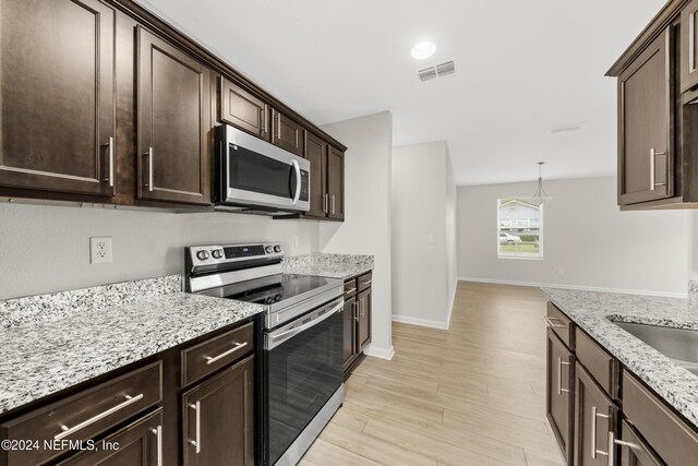 kitchen featuring pendant lighting, dark brown cabinetry, appliances with stainless steel finishes, and light hardwood / wood-style flooring