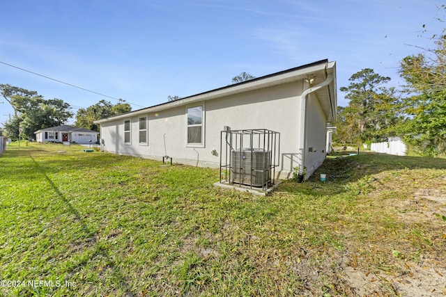 back of house with a yard and cooling unit