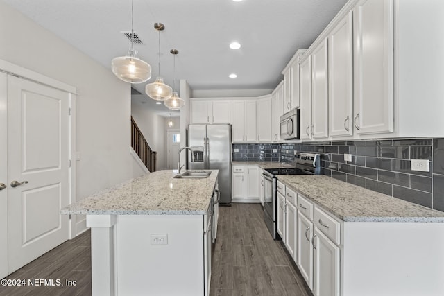 kitchen featuring white cabinets, dark hardwood / wood-style flooring, stainless steel appliances, and an island with sink