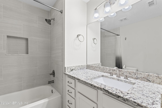 full bathroom featuring vanity, tiled shower / bath combo, and toilet