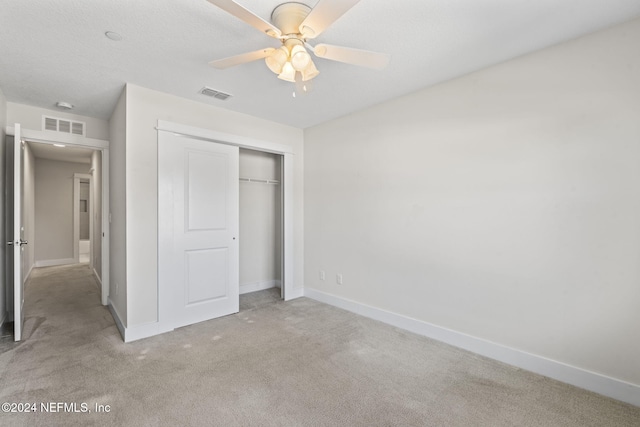 unfurnished bedroom with light carpet, a closet, and ceiling fan