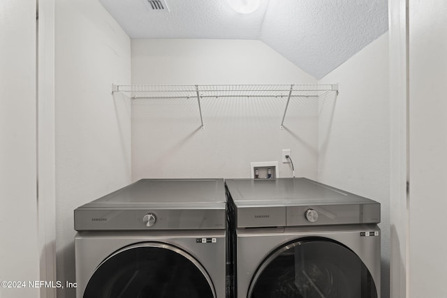 washroom featuring separate washer and dryer and a textured ceiling