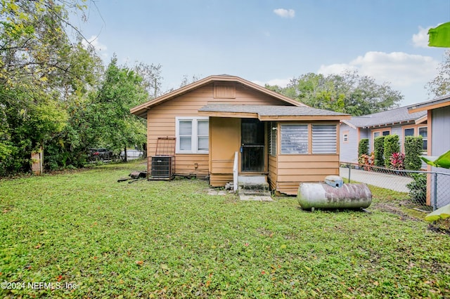 back of property with a yard and central air condition unit