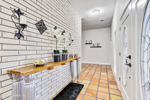 interior space featuring wood counters, light tile patterned floors, and brick wall