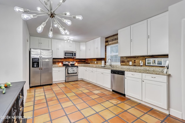 kitchen with tasteful backsplash, white cabinets, and appliances with stainless steel finishes