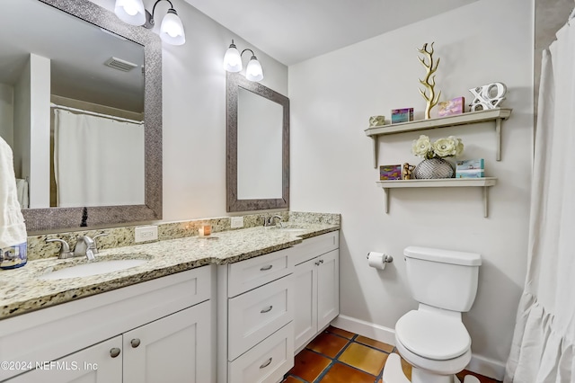 bathroom featuring tile patterned flooring, vanity, and toilet