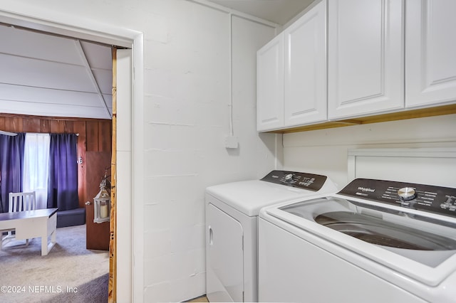 clothes washing area featuring cabinets, light colored carpet, and washer and clothes dryer