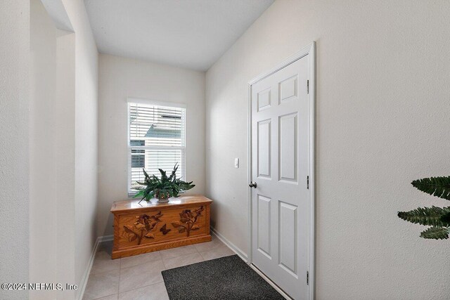 doorway to outside with light tile patterned floors