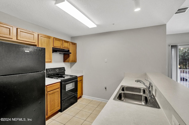 kitchen with black appliances, light tile patterned floors, sink, and a textured ceiling