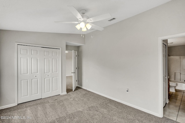 unfurnished bedroom featuring carpet flooring, ceiling fan, connected bathroom, a closet, and lofted ceiling