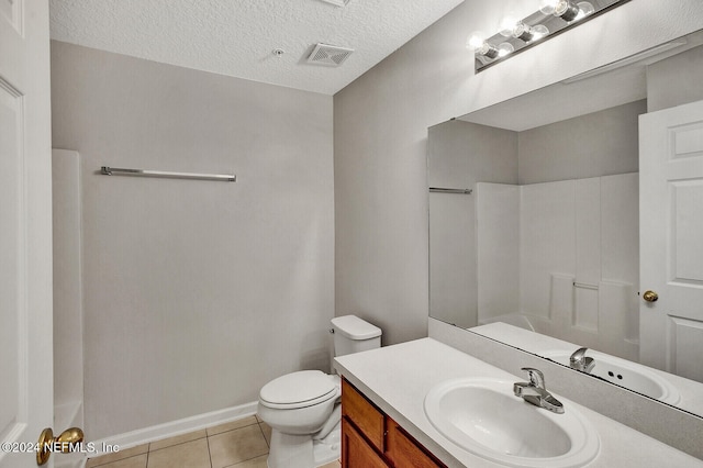 bathroom featuring tile patterned flooring, vanity, a textured ceiling, and toilet