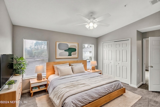 bedroom featuring ceiling fan, a closet, carpet floors, and vaulted ceiling